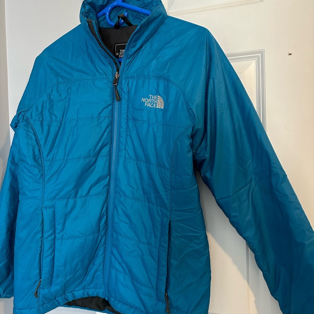 The North Face Blue Puffer Jacket with High Collar and Full-Length Zipper
